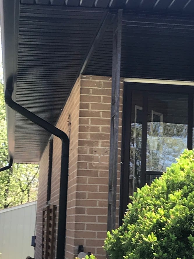 Close-up of black eavestrough and downspout installation