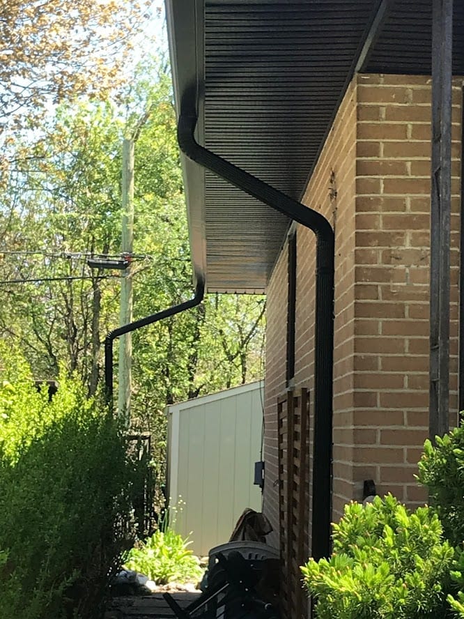 Side run of eavestroughs and downspouts on a brick home